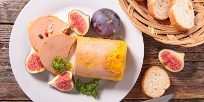 Terina z foie gras, fíky a bagetka na talíři 