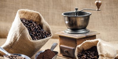 Starý mlýnek na kávu, zrnka kávy v hrubém pytlíku