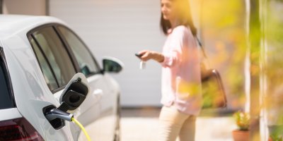 Žena zamyká nabíjející se elektromobil