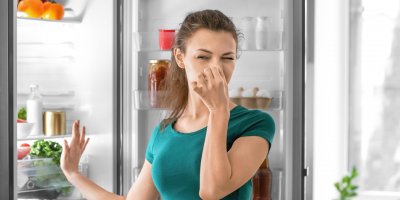 Žena si ucpává nos u otevřené ledničky