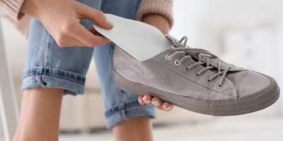 Žena vkládá do obuvi vložky do bot