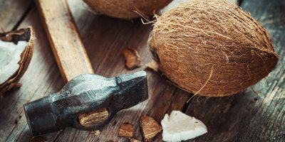 kokosový ořech a kladivo položené na stole